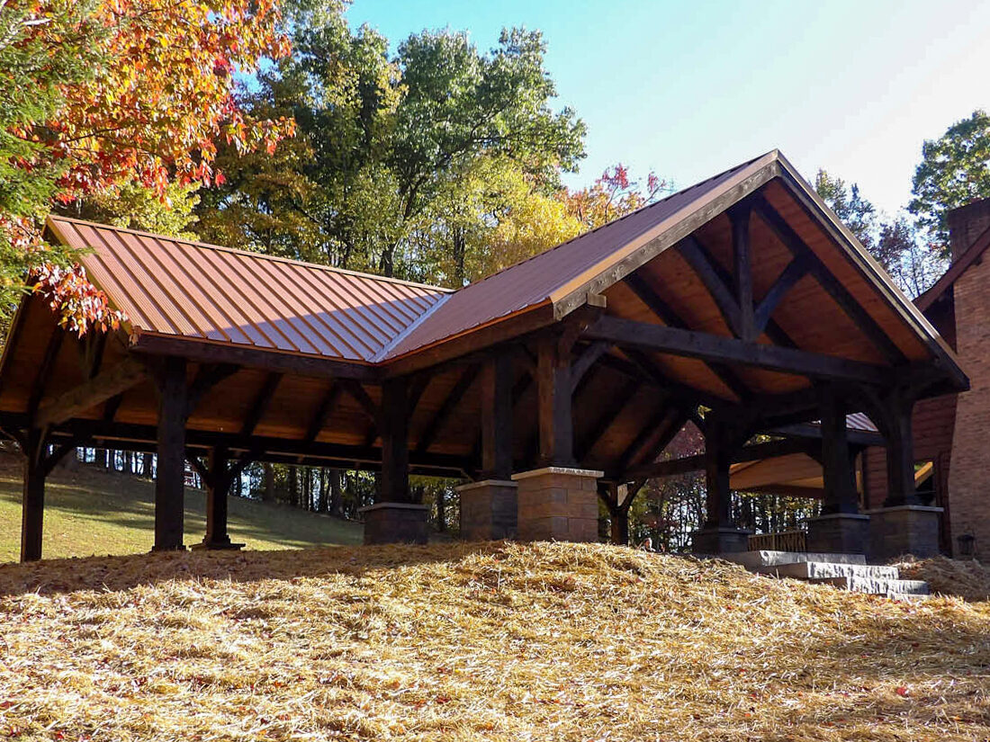 A custom outdoor timber structure in Montana on top of a small hill next to a house